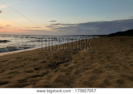 late in the evening on the sea, dark, beautiful landscape with sea waves and dark sky with bright orange stripes, cloudy, skyline, night, vespertine, extramural, afterdark