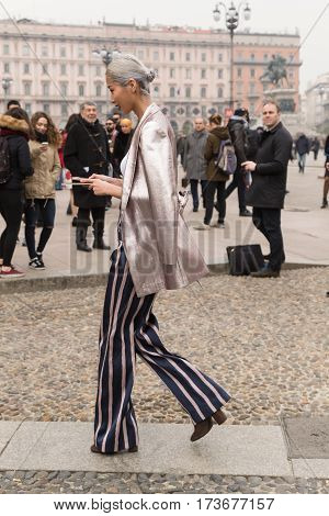 MILAN ITALY - FEBRUARY 23: Fashionable woman poses outside Genny fashion show during Milan Women's Fashion Week on FEBRUARY 23 2017 in Milan.