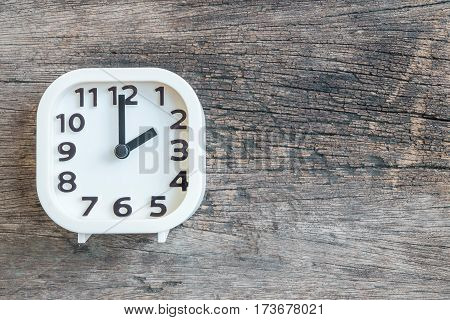 Closeup white clock for decorate in 2 o'clock on old wood floor textured background with copy space