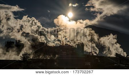 Smoking chimneys and shinning sun in factory Mondi Ruzomberok - Slovakia. Air pollution