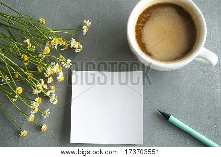 Daisy bouquet with coffe and sticker on concrete background