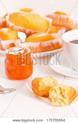 Breakfast with plumcake and apricot jam on white dish.