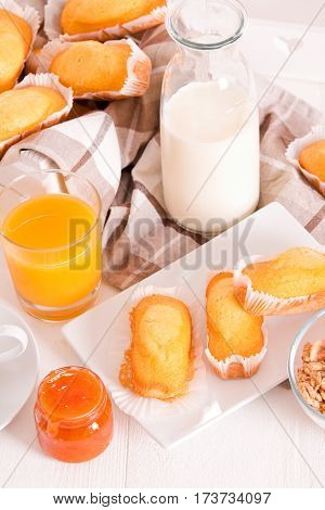 Breakfast with plumcake and orange juice on white dish.