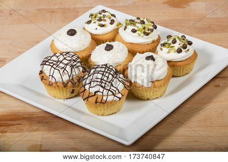 cupcakes with vanilla butter cream frosting on woodenbackground