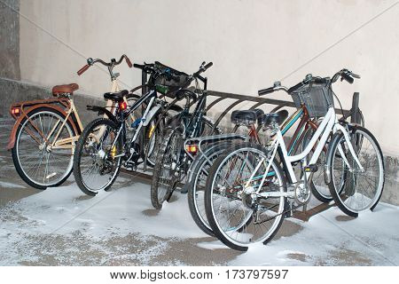 Bikes in the snow on campus. Twilight.