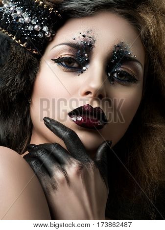 Beauty portrait of young woman with modern fashion makeup with rhinestones. Studio shot. Carnival or party makeup