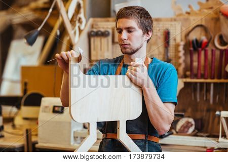 Self-employed cabinetmaker processing plank in his workshop