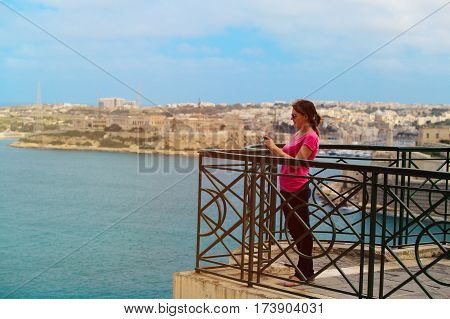 young tourist making photo of Valetta, Malta, travel concept
