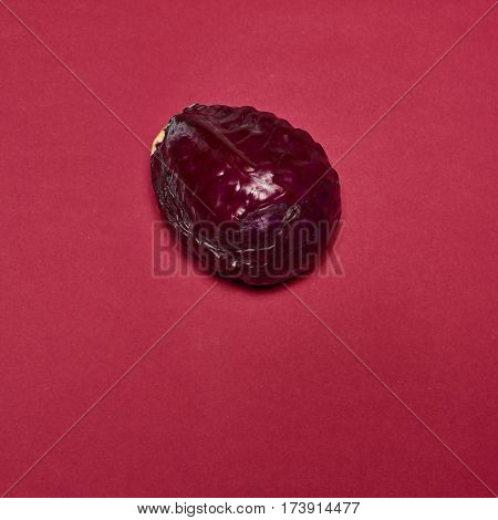 The fresh red cabbage on a red background