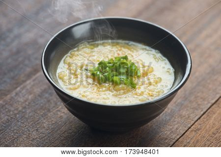 Congee bowl on wooden table background.