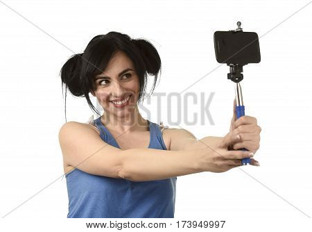 young attractive and sexy woman taking selfie photo with stick and mobile phone camera posing happy and playful isolated on white background in shooting self portrait concept