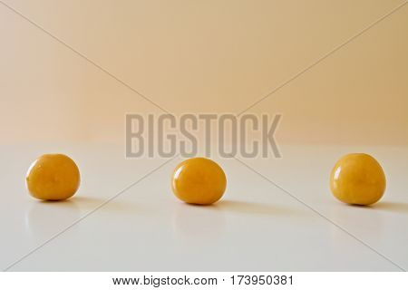 Three golden berries on the white table