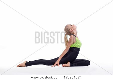 Breathing in. Profile shot of a beautiful young woman practicing yoga sitting on the floor stretching her back isolated copyspace