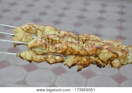 fresh roast chicken shish kebab on skewers at outdoors