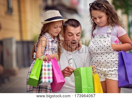 Happy father with children have a successful day of shopping