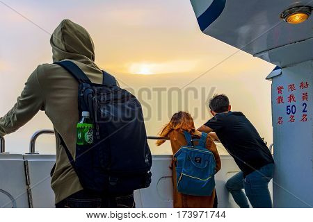 TAIPEI TAIWAN - JANUARY 05: People looking at the view of the sunset over the sea from a boat in the Tamsui area of Taipei on January 05 2017 in Taipei