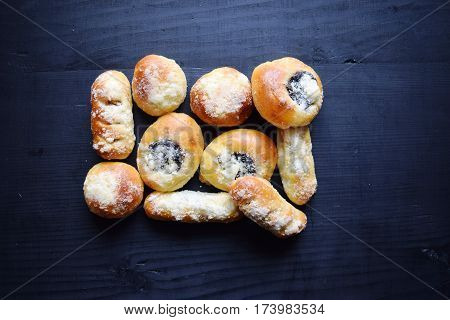 Homemade buns stuffed with jam on a black wooden background