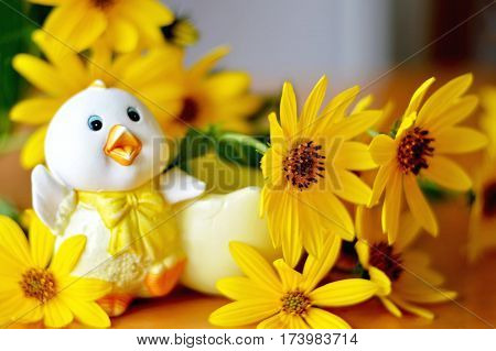 Cute Easter chicken and yellow flowers on the table
