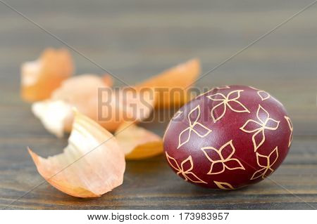 Easter egg decorated with wax on wooden background