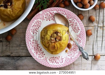Baked Apples With Raisins, Hazelnuts And Cinnamon On Wooden Background. Rustic Style.