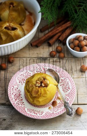 Baked Apples With Raisins, Hazelnuts And Cinnamon On Wooden Background. Rustic Style.