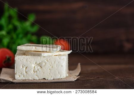Large Piece Of Feta Cheese On Dark Wooden Table. Selective Focus.