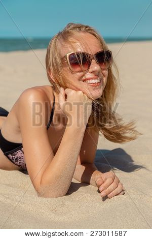 Single Happy Young Blond Woman In Swimsuit And Sunglasses At Sand Sea Beach Looking At Camera Smilin
