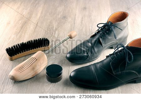Black Leather Dress Boots, Shoe Stretcher And Brush On A Wooden Floor