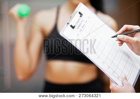 Fitness Plan. Sports Trainer Amounts To Workout Plan Close-up