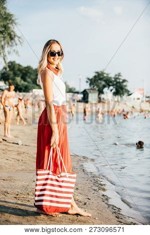 Woman In Sunglasses Walking With Bag On Sand Beach