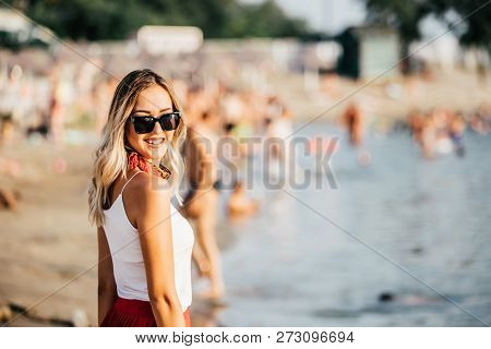Young Woman In Sunglasses Walking At The Beach