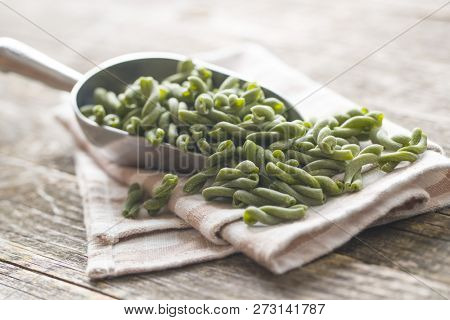 Uncooked spinach gemelli pasta in scoop.