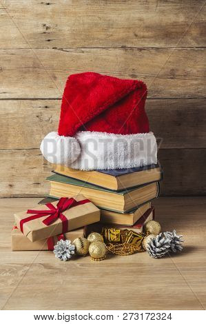 A Stack Of Books, Santa Clauss Cap, An Alarm Clock, Cones, Christmas-tree Decorations, Gift Boxes On