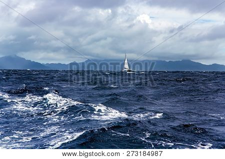 Lonely Catamaran In Turbulent Pacific Ocean Near The Islands In French Polynesia