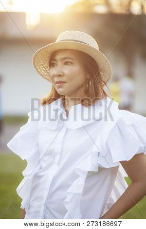 Portrait Of Beautiful Asian Woman Wearing Straw Hat Against Beautiful Sun Light