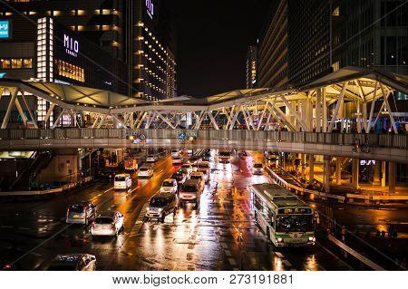 Osaka, Japan - December 6, 2018: Lights From Traffic Reflect Of Puddles In Intersection After Rain I
