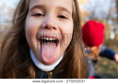 Portrait Of A Young Girl Sticking Out Tongue