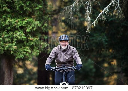 Active Senior Man With Electrobike Cycling Outdoors On A Road In Nature.