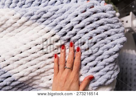 The Girl Is Holding A Knitted Soft Blanket In Her Hands, Close Up.