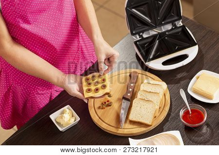 Detail Of Female Hands Adding Olives On A Sandwich; Woman Making Hot Sandwiches For Breakfast In A S