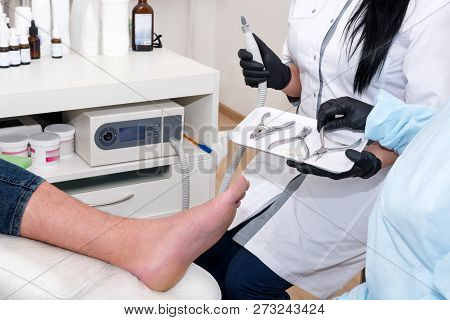 Podology Treatment. Podiatrist Treats Foot. Podiatry Doctor Or Dermatologist Treats The Patient In M