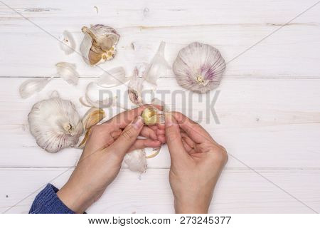 Woman Hands Are Spliting Garlic Cloves. Recipe Step By Step Baked Potatoes With Onion Flatlay On Whi