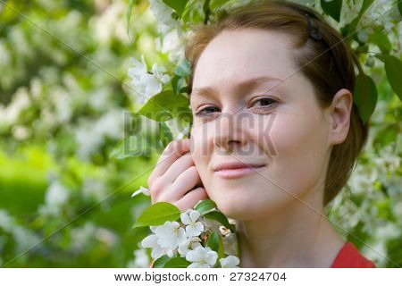 Giovane e bella donna in un giardino fiorito