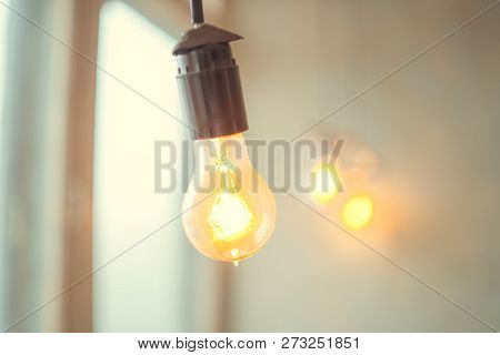 Retro Vintage Light Bulb With Led Technology Bult-in On Warm Light Yellow Tint And Black Background 