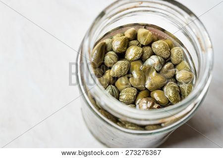 Jar Of Capers In Glass Bowl.