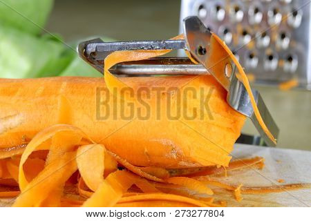 Fresh Carrot Grated On A Metal Kitchen Grate. Vegetables Prepared For Salad With A Meal On The Kitch