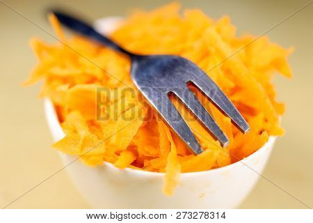 Fresh Carrot Grated On A Metal Kitchen Grate. Vegetables Prepared For Salad With A Meal On The Kitch