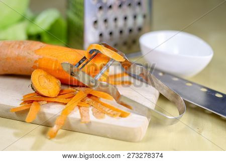 Fresh Carrot Grated On A Metal Kitchen Grate. Vegetables Prepared For Salad With A Meal On The Kitch
