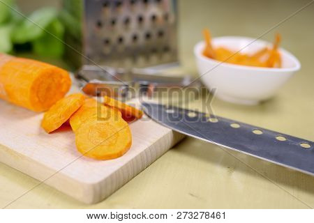 Fresh Carrot Grated On A Metal Kitchen Grate. Vegetables Prepared For Salad With A Meal On The Kitch