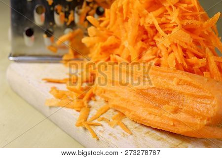 Fresh Carrot Grated On A Metal Kitchen Grate. Vegetables Prepared For Salad With A Meal On The Kitch